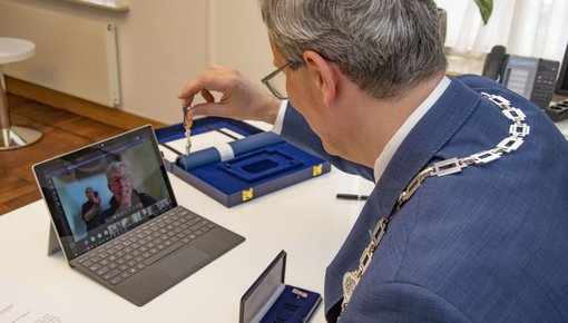 Burgemeester Weys reikt digitaal een Koninklijke onderscheiding uit aan René Uytdewilligen